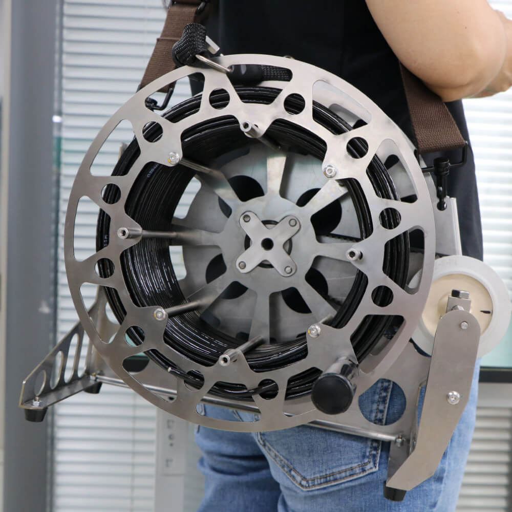 Hand-crank subsea tether reel spooled with optical fiber cable featuring foldable handle and ground frame